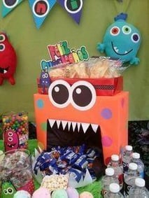 an orange monster cake with candy and candy to denote a monster theme birthday party for kids.